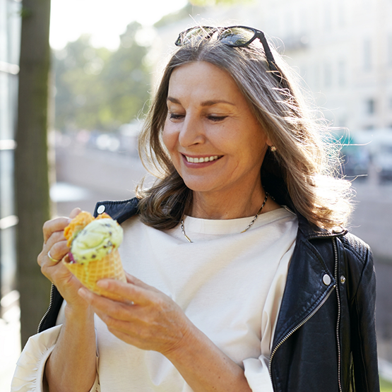 Smiling woman eating ice cream cone