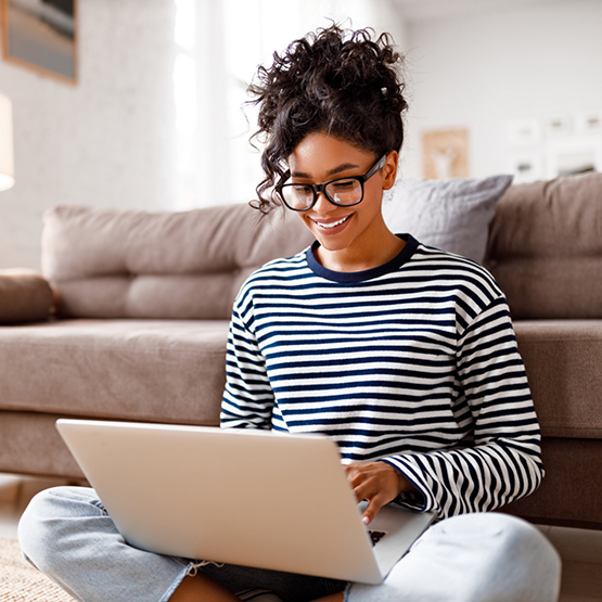 Young woman smiling while using her laptop