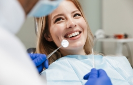 Woman in dental chair grinning at her dentist in Reno