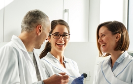 Three dentists smiling while having discussion