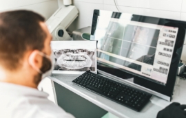 Dentist looking at computer showing x rays of teeth