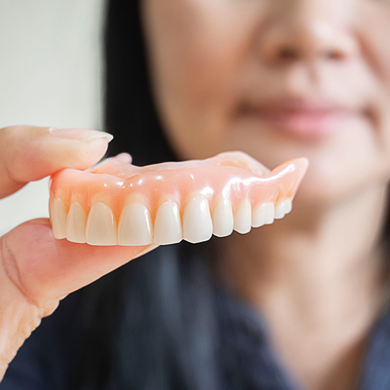 Dental professional holding a denture