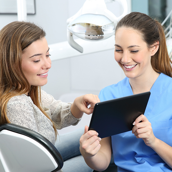 Dentist showing a tablet screen to a patient