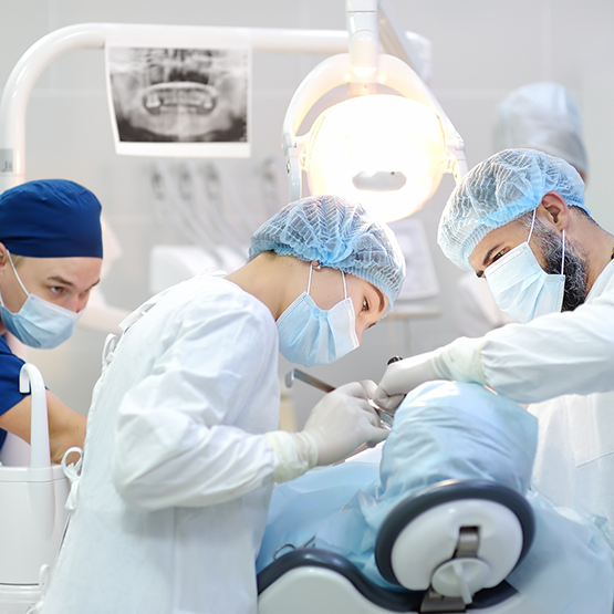 Dentist and two assistants performing wisdom tooth extraction in Reno